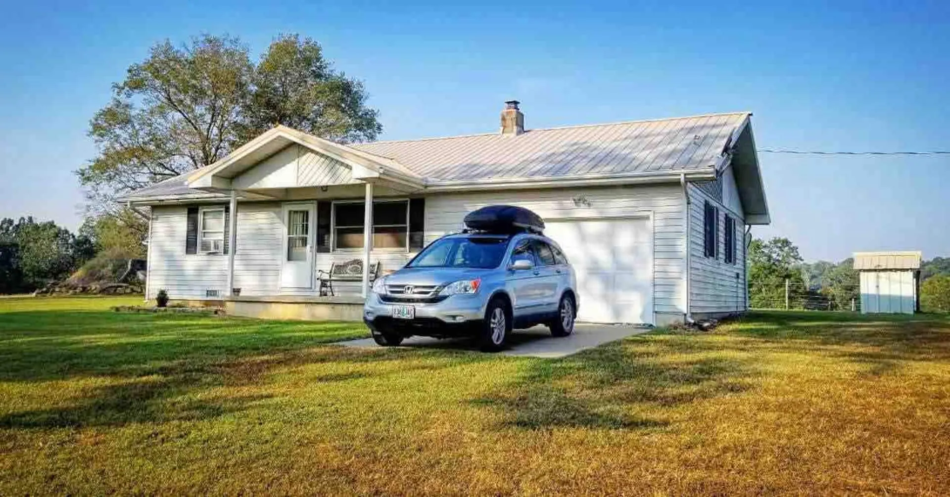 Front of the farmhouse with free parking on the grass and a wide open lawn